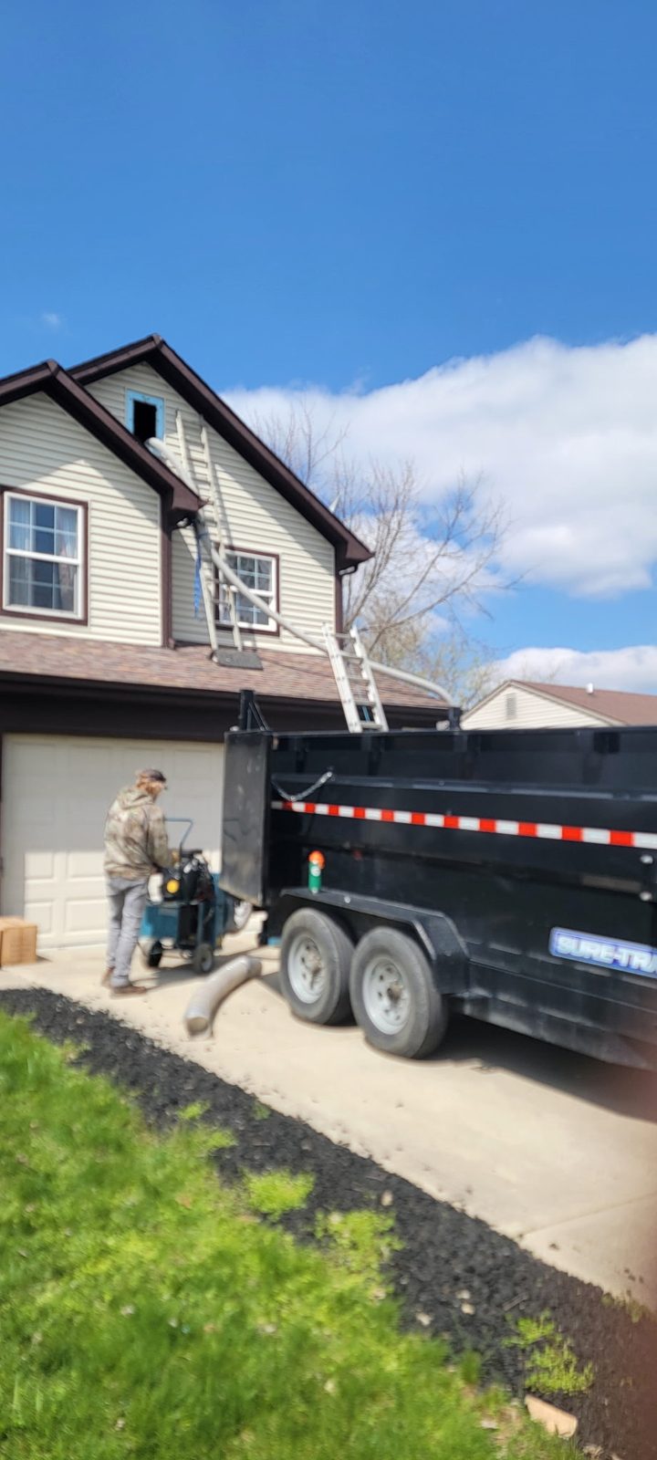 Wildlife Guys crew working from trailer rig with ladders to the attic